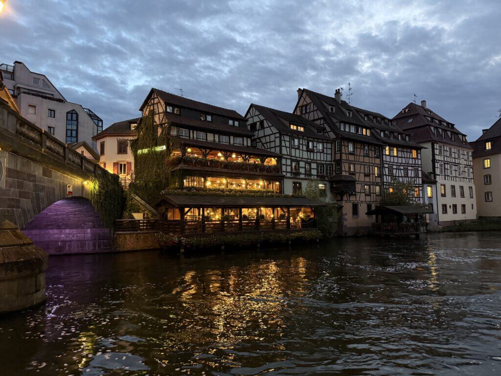 Gezellig restaurant langs de rivier in Heidelberg met verlichte terrassen en historische gebouwen.