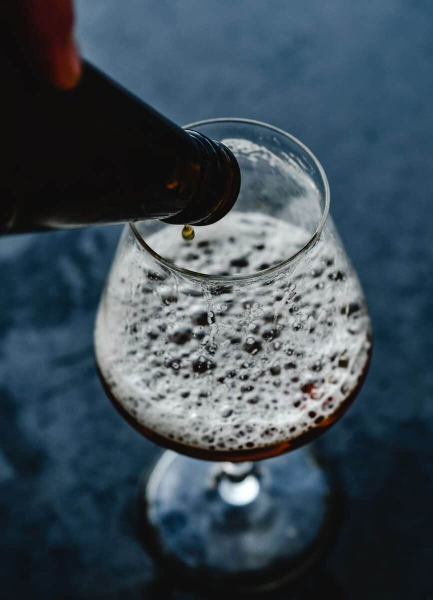 Bier wordt ingeschonken in een glas met schuim bij Nevel Artisan Ales.
